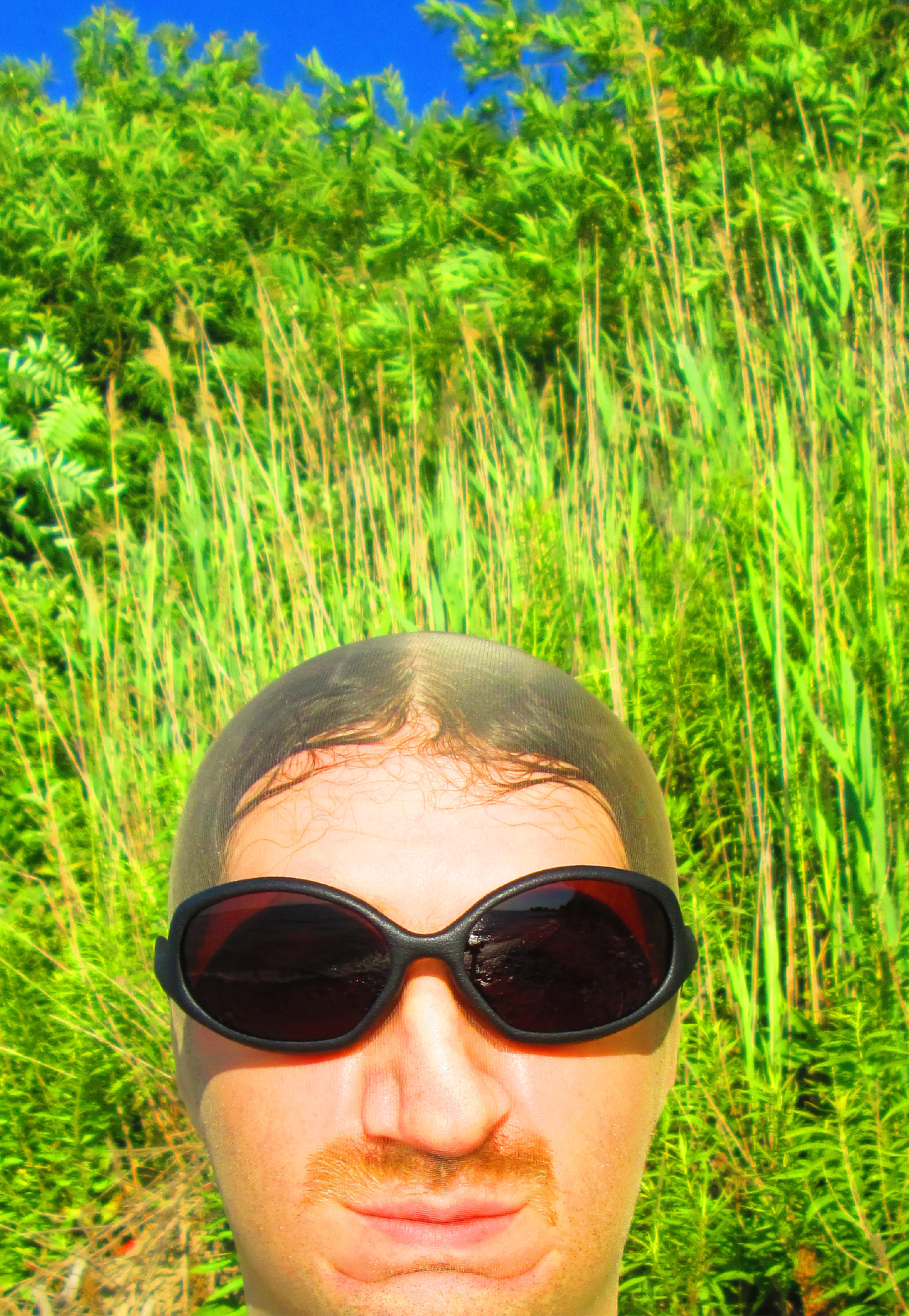 3D render of a bald model wearing black sunglasses with transparent grey lenses